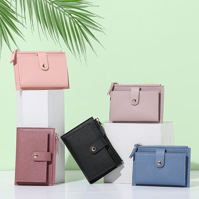 Portefeuille pour Femmes à Multiples Fentes pour Cartes, Fermeture Éclair Lisse, Similicuir, Petit Format, Texture Fine, Portefeuille Court pour le Magasinage, Offert en Cinq Couleurs : Rose, Noir, Bleu, mauve et Rose Pâle. design Compact et portable avec Fermeture Éclair Lisse et Fermeture à Boucle, Idéal pour Ranger Cartes, Argent, Pièces et photos. Positionné sur des Blocs Blancs sur un Fond Vert Pâle avec des Feuilles de Palmier, Soulignant Son Usage comme Accessoire pour Femmes.