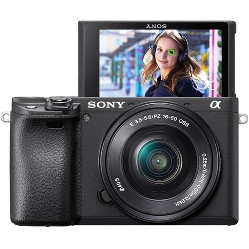 Sony a6400 Mirrorless Camera with 16-50mm Lens, Black (EOL) (International Model) shown in a front-facing view. The camera features a compact black body with a textured grip on the left side and a 16-50mm lens attached. The flip-up LCD screen displays a vibrant image of a person wearing headphones, showcasing the camera's real-time focus and tracking capabilities. Ideal for capturing dynamic scenes and action shots with its advanced autofocus system and AI-powered subject tracking.