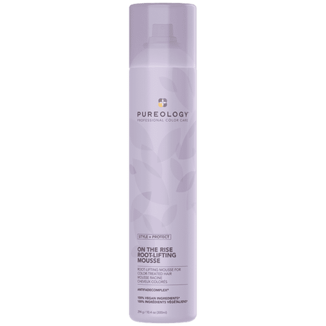 Pureology Style + Protect On The Rise Root Lifting Mousse, 10.4 oz, in a sleek lavender cylindrical bottle with a pump dispenser. Designed for color-treated hair, it provides root lift, body, and shine with vegetable protein and a signature aromatherapy blend of tuberose, almond milk, and cedarwood. The formula is 100% vegan, free from sulfates, parabens, and animal testing, and includes the patented Antifade Complex® to protect color vibrancy.