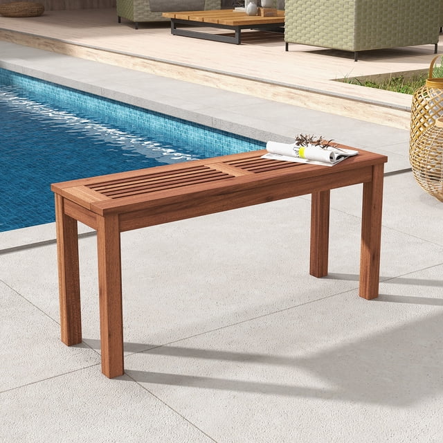 Gymax 2-Person Outdoor Bench Patio Bench with slatted seat and weather-resistant solid wood frame, measuring 39.5'' x 12'' x 18.5''. The natural wood finish complements outdoor settings, shown placed by a poolside on a patio. Features sturdy thickened wood legs and a breathable slatted design for comfort. Suitable for gardens, backyards, or indoor entryways.