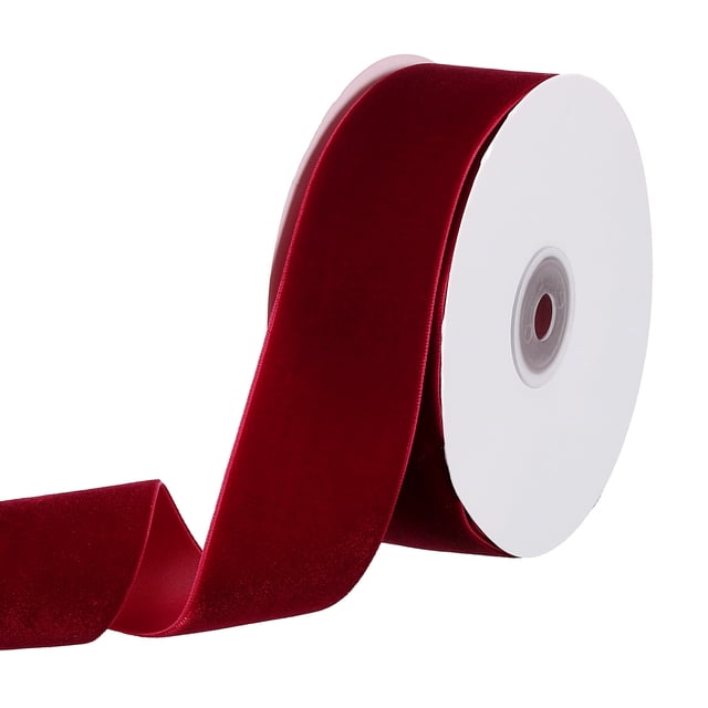 Unique Bargains 1-1/2' 10 Yard Velvet Ribbon Polyester Single Face Spool in burgundy. The ribbon features a soft velvet texture with a polyester backing for durability. Measuring 38mm wide and 9.14 meters long, it is ideal for gift wrapping, floral arrangements, wedding decorations, and various DIY crafts. The spool is shown with the ribbon partially unrolled, highlighting its rich burgundy color and smooth finish.