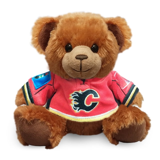 Forever Collectibles Calgary Flames Jersey Sweater Bear, a plush brown teddy bear wearing a red Calgary Flames jersey with the team logo prominently displayed on the front. The bear measures 7.5 inches tall and is made of polystyrene pellets and polyester fleece. Officially licensed NHL merchandise, ideal for fans as a gift or decoration.