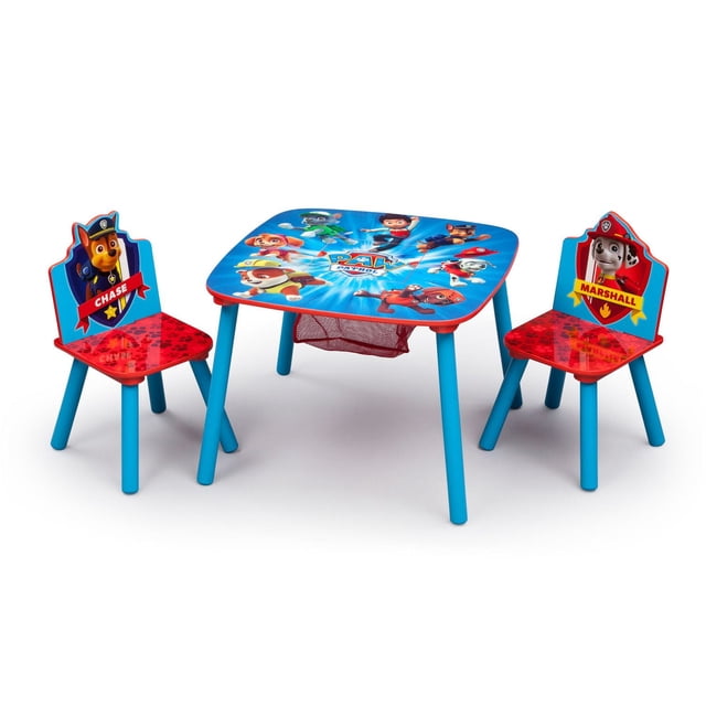 PAW Patrol Table & Chair Set with Storage featuring a square table with blue legs and a colorful tabletop graphic of PAW Patrol characters, including a built-in mesh storage basket underneath. Two matching chairs have blue legs, red paw-print seats, and backrests with Chase and Marshall character images and names.