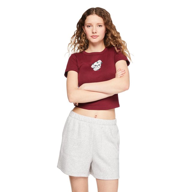 No Boundaries Women's Rib Baby Tee in burgundy featuring a small skull and floral graphic on the chest, rib knit fabric, crew neckline, and short sleeves, paired with light grey elastic waist shorts in a front-facing pose.