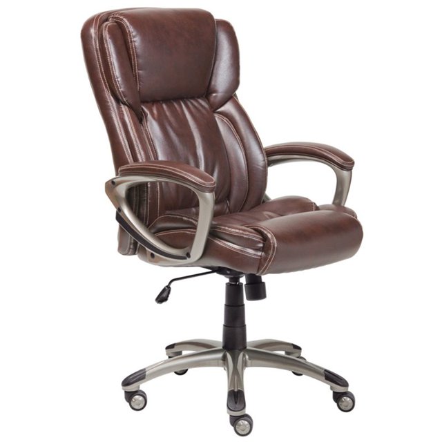 Serta at Home Works Executive Office Swivel Chair in Brown featuring a faux leather finish with contoured lumbar support and deep layered foam cushions for ergonomic comfort. The chair includes padded armrests, a height-adjustable seat, and a sturdy metal base with five caster wheels for mobility. Dimensions are 42 inches high, 26 inches wide, and 30 inches deep.