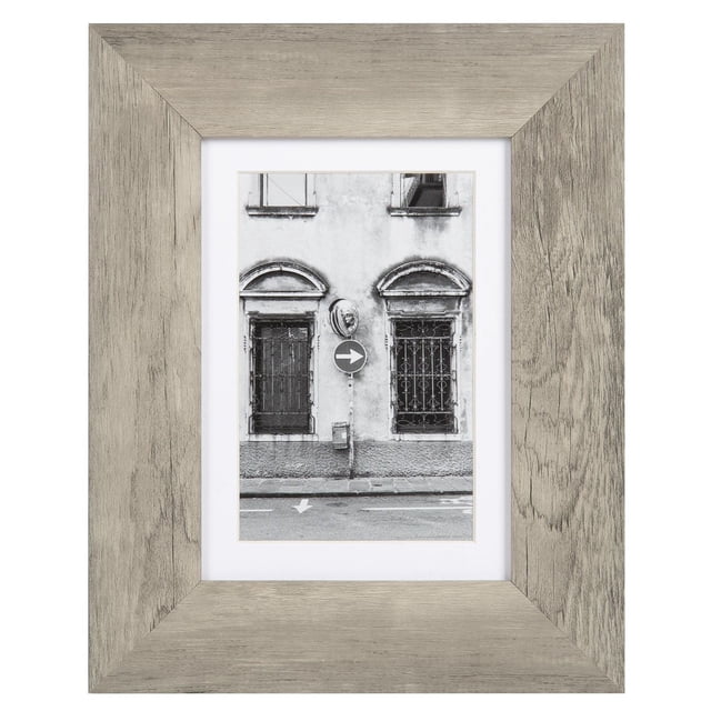 hometrends Benoit Picture Frame in grey rustic wood finish, holding a 5x7 black and white photo of a building facade with two arched windows and a right arrow street sign, suitable for vertical or horizontal display with included mat and easel for tabletop or wall mounting.