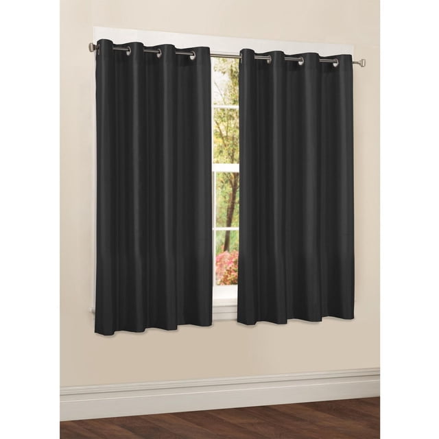 Mainstays Faux Silk Drapery Grommet Window Curtains Panel in black, hanging on a silver curtain rod over a window with outdoor greenery, made of semi-sheer polyester fabric with subtle sheen and metal grommets for easy installation, ideal for refreshing room décor and light filtering.