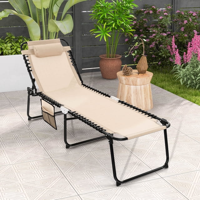 Costway Chaise Longue Pliante de Patio 1 Pce Chaise Longue Portable avec Dossier Réglable, Conçue pour l'Extérieur. la Chaise beige Présente un Cadre en Métal Noir durable, un Tissu Respirant, un Appui-Tête Amovible et une Poche Latérale pour Plus de Commodité. Elle Se Déplie sur un Patio Carrelé Entouré de Plantes, Convient pour Bronzer, Lire Ou Se Détendre.