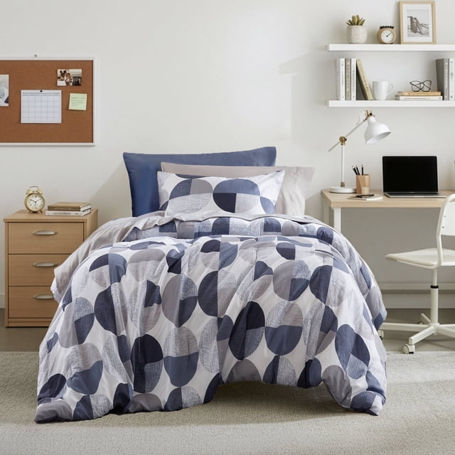 Regency Heights Ensemble de Douillette Format Simple, Ensemble de Lit 6 Pcs avec Imprimé Géométrique Rond Bleu Marine, Idéal pour la Literie pour Enfants. Comprend une Douillette, un Drap-Housse avec Poches Latérales, un Drap Plat, des Taies d'Oreiller et des Couvre-Oreillers, Fabriqué en Microfibre Douce et Respirante. Montré dans une Chambre Moderne pour Enfants avec un Bureau et des Étagères en Arrière-Plan.