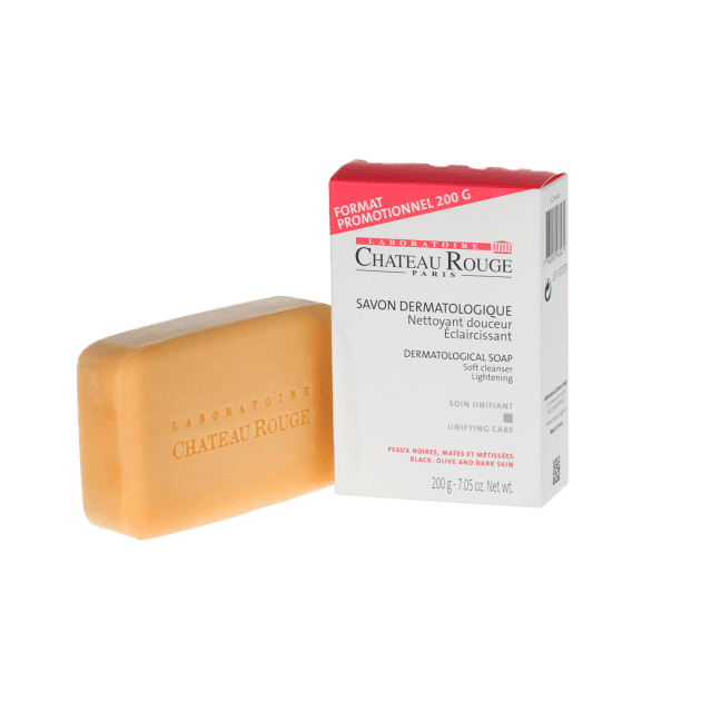Chateau Rouge Dermatological Soap 200g, a rectangular amber-colored bar soap with embossed branding, paired with its white and red packaging. This soap cleanses, brightens, and purifies skin, leaving it radiant and luminous. Suitable for all skin types and free from parabens and phenoxyethanol.