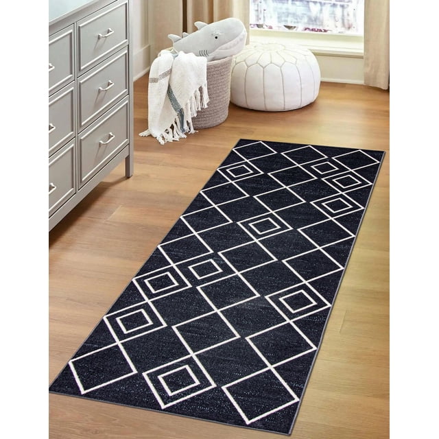 ECARPET washable geometric area rug and runner in black with white square patterns, low pile 3mm polyester on hardwood floor beside gray dresser, woven basket with white throw and shark plush, and white pouf near window, ideal for high traffic areas.