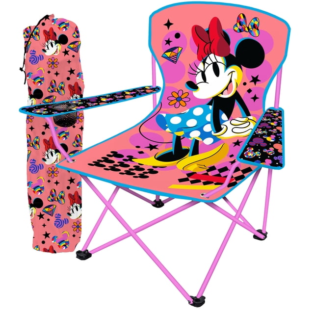 Danawares Minnie Mouse Youth Camping Chair with Cup Holder - Polyester featuring a pink steel frame and bright pink polyester fabric printed with a large Minnie Mouse graphic wearing a red bow and blue polka dot skirt. The chair includes black armrests with colorful patterns and a built-in cup holder on the right side. It folds for portability and comes with a matching pink storage bag decorated with Minnie Mouse and colorful designs, suitable for camping, picnics, and outdoor events.