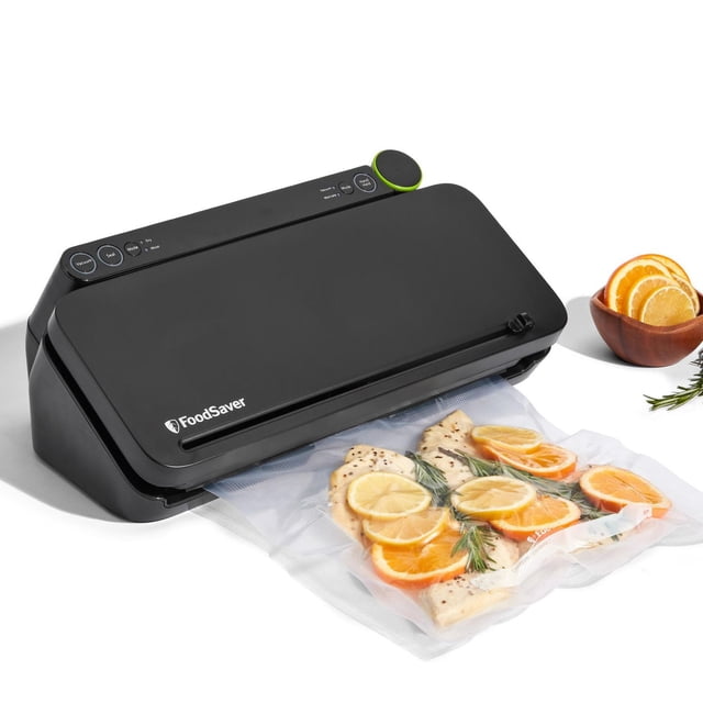 FoodSaver Premier Scelleuse sous Vide Multi-Usage avec Scelleuse Portative Intégrée en Noir Mat, Scelle un Sac sous Vide Contenant des Poitrines de Poulet Assaisonnées avec des Tranches de Citron, d'Orange et de Romarin sur une surface Blanche, avec un Bol en Bois de Tranches d'Agrumes à Proximité, Convient pour Prolonger la Fraîcheur des Aliments jusqu'à 5 Fois Plus Longtemps.