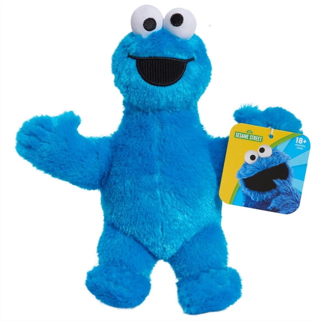 Sesame Street Friends Plush Cookie Monster, an 8-inch blue plush toy with soft fuzzy fabric, large white eyes with black pupils, and a wide black smiling mouth, holding a Sesame Street tag, ideal for imaginative play and cuddling for children 18 months and older.