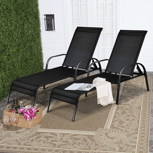 Gymax Chaise Longue Inclinable de Patio Réglable - Ensemble de 2, Noir. une Paire de Chaises Longues d'Extérieur avec Cadres en Acier Enduit de Poudre et Sièges en Tissu Noir Respirant, Placées sur un Tapis d'Extérieur à Motif beige Près d'Un Mur Blanc et d'Une Haie Verte. Comprend Cinq positions de Dossier Réglables, des Accoudoirs Courbés et un design Léger pour la Portabilité. Idéal pour patios, Bord de Piscine, Balcons Ou Jardins.