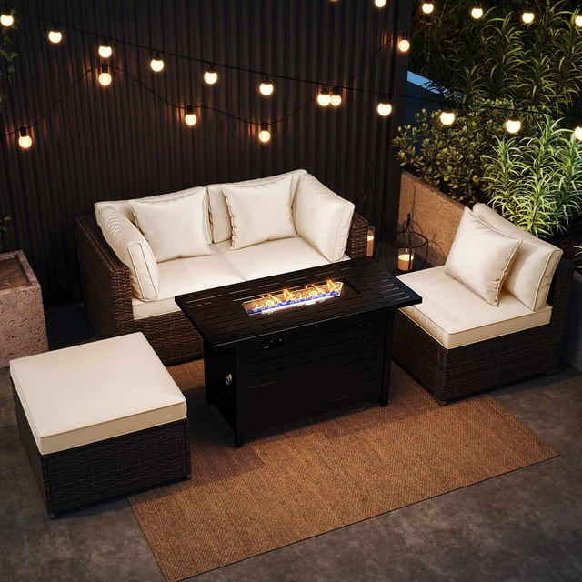 Costway 5 PCS Patio Furniture Set with a heavy-duty frame and premium PE rattan construction. Includes two corner sofas, one armless sofa, an ottoman, and a 60,000 BTU firepit table that converts into a coffee table. Features white, high-density sponge cushions with zippered, breathable covers for easy cleaning. The firepit table has a black metal finish and is shown in a stylish outdoor setting with string lights and greenery.