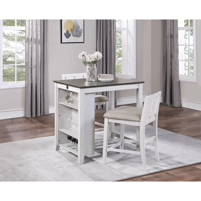 Topline Home Furnishings Multi-Functional White 3pc Dining Set with a counter-height table in two-tone white and grey Mindy veneer, built-in display shelves, and two USB ports, paired with two wood-framed low-back chairs with grey polyester fabric seats, set on a light grey rug in a bright room with large windows and grey curtains, ideal for compact dining or casual workspaces.