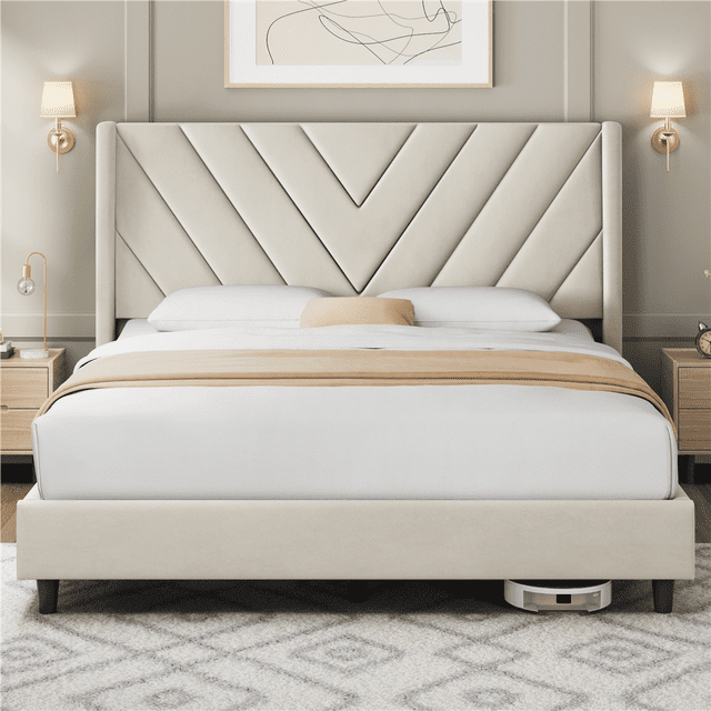 Fullfurnique Upholstered Platform Bed Frame with Wooden Slat Support, Queen, Beige, showing a beige velvet wingback headboard with geometric stitching, solid wood slats supporting the mattress without a box spring, and reinforced legs, placed in a neutral-toned bedroom with matching nightstands and wall sconces, ideal for modern bedroom interiors.