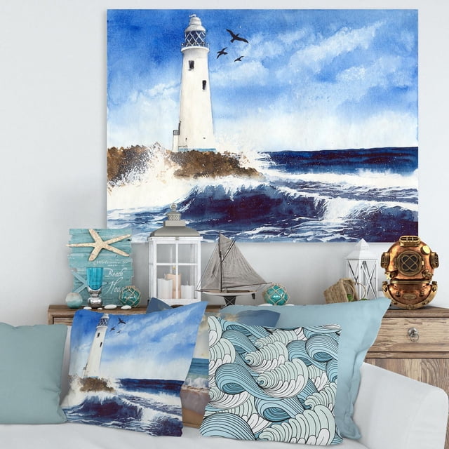 Designart Lighthouse On The Rocky Island With Seagulls Canvas Wall Art depicts a white lighthouse on rocky shore with crashing ocean waves and three seagulls flying in a blue sky, printed on premium cotton canvas with gallery wrap, suitable for nautical and coastal home décor.