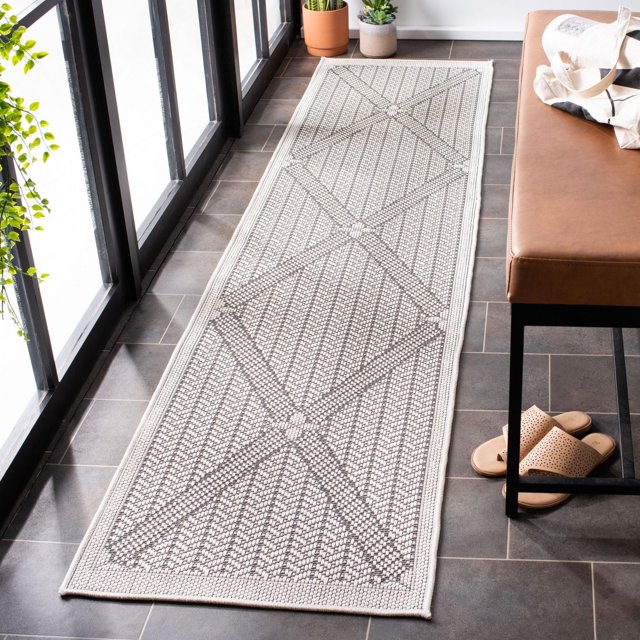 SAFAVIEH Bermuda Julijana Tapis d'Extérieur à Losanges Géométriques, un Coureur Résistant aux Intempéries avec un Tissage Texturé et un Motif de Losanges Géométriques dans des Tons Neutres, Posé sur un Plancher de Tuiles Foncées à Côté d'Un Banc en Cuir Brun et des Plantes en Pot Près de Grandes Fenêtres, Idéal pour les patios Ou Entrées Extérieurs.