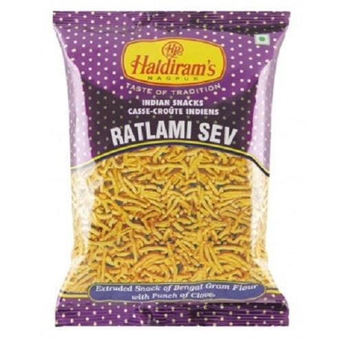 Haldiram Loung Sev Ratlami 150 G in a purple polka-dotted bag with brand logo and product name, showing yellow extruded Ratlami sev made from Bengal gram flour with clove, a traditional Indian snack often used to add texture to dishes like upma and poha.