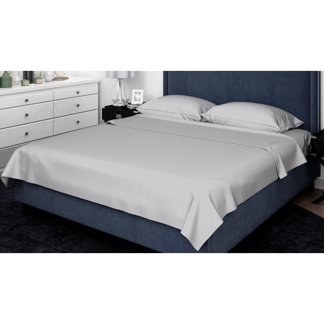 Johnson Home 500 Thread Count Combed Cotton Sheet Sets in light grey on a navy blue upholstered bed with a tall headboard, featuring smooth, breathable cotton sateen fabric and two matching pillowcases, set in a modern bedroom with white dresser and glass lamp.