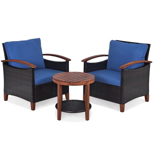 Giantex 3 Pieces Patio Furniture Set, a conversation bistro set with two rattan chairs featuring acacia wood frames and blue cushions, paired with a round acacia wood side table with a lower rattan shelf. The chairs offer wide armrests, backrests, and removable washable cushions for comfort. Made with weather-resistant materials, this set is ideal for outdoor use in gardens, balconies, or backyards.