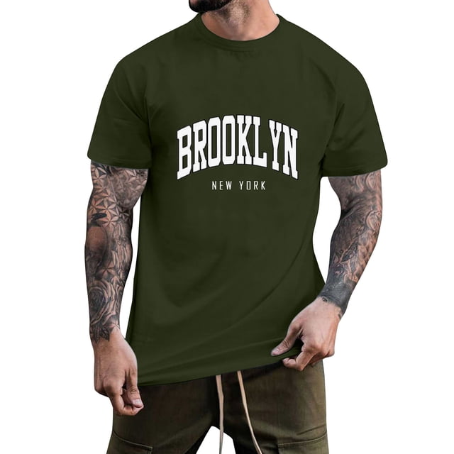 BOBOGOJP Men's Adult Short Sleeve Tee in XL size, featuring a crew neck design and solid color pullover style. The shirt displays a bold 'Brooklyn New York' graphic print on the front, made from a premium cotton blend fabric with a soft texture. Ideal for casual wear, work, or lounging, paired with jeans or shorts. This men's graphic t-shirt is shown in a dark green color, modeled with tattooed arms visible.