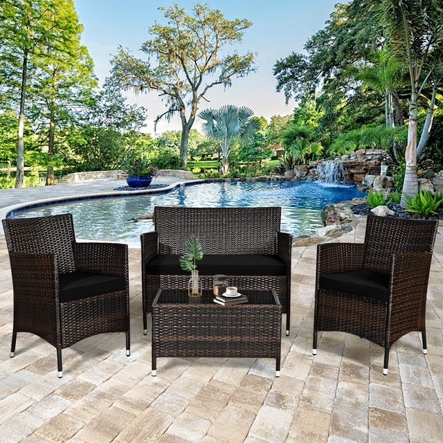 Gymax Ensemble de Conversation en Rotin pour Patio 4 Pcs pour l'Extérieur avec Coussin Noir, Incluant Deux sofas Simples, un Causeuse et une table Basse avec Verre Trempé. Fabriqué avec Mélange de Rotin Brun et d'Acier, l'Ensemble Comprend des Coussins Noirs Amovibles pour un Entretien Facile. Présenté dans un Patio au Bord de la Piscine avec une Verdure Vibrante.