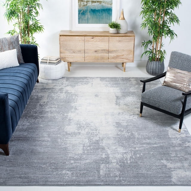 SAFAVIEH Jasper Tapis Alvina Abstrait Surteint Mettant en Vedette une Laine Synthétique à Poils Doux avec un Motif Abstrait Gris et Blanc Cassé, Exposé dans un Salon Contemporain entre un sofa en Velours Bleu Marine et un Fauteuil Noir à Motifs, Près d'Une console en Bois Clair Sculpté et des Plantes Vertes, Idéal pour Accentuer les Intérieurs Modernes.