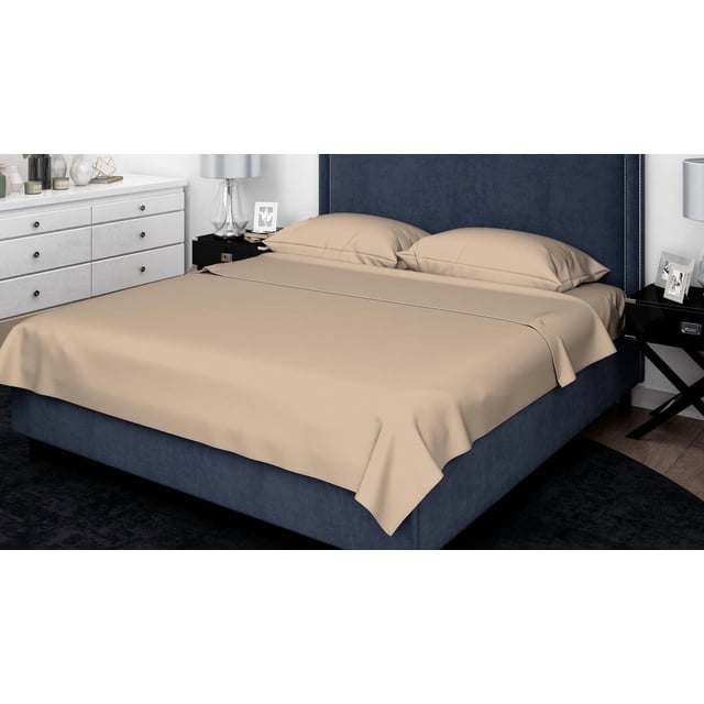 Johnson Home 1000TC Egyptian Cotton Sheet Sets in beige on a navy blue upholstered bed with nailhead trim headboard, featuring a smooth flat sheet and two pillowcases made from breathable, durable fabric, set in a modern bedroom with white dresser and black nightstands.