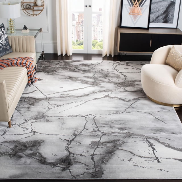 SAFAVIEH Craft Paul Abstract Marble Area Rug, 6'7" x 6'7" square grey and silver accent rug with swirling marble-inspired abstract patterns and subtle etched pile texture, shown in a contemporary living room with dark hardwood floors, beige tufted sofa, and cream round armchair, ideal for modern home or office decor.