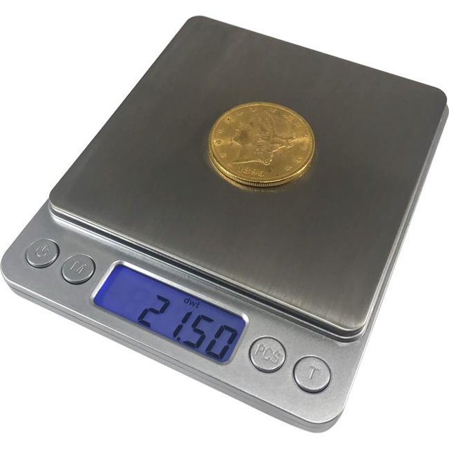 Optima Balances pour la Maison TI-2001 Plateforme en Titane et Acier Inoxydable Grande Balance de Poche avec une Capacité de 2000 g x 0,01 G. l'Image Montre la Plateforme en Acier Inoxydable Scale's avec une Pièce d'Or Placée Dessus. l'Affichage Numérique Lit 21,50 Pds, et les Boutons de Contrôle Sont Visibles sous l'Écran. Idéal pour Peser des Bijoux, des Grains de Café, des Médicaments et des Articles de Loisir.