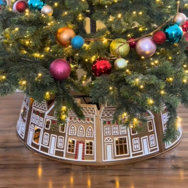 EGNMCR Gingerbread House Christmas Tree Collar with LED lights, designed as a 28-inch diameter PVC Christmas tree skirt. The collar features detailed white snowflake patterns and gingerbread house designs on curved panels. Displayed under a festive Christmas tree adorned with colorful ornaments and warm string lights.