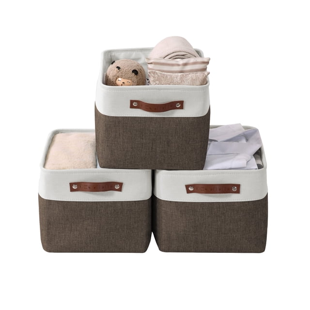 DECOMOMO Grand Panier de Rangement Bacs de Rangement en Tissu, Ensemble de 3, Brun et Blanc. l'Image Montre Trois Bacs de Rangement Pliables au design Bicolore avec Tissu Brun et Garniture Blanche. Chaque Bac a des Poignées en Similicuir Durables et Est Rempli de Divers Articles comme des Serviettes, des Jouets et des Vêtements. Ces Bacs Sont Conçus avec une Plinthe en MDF Robuste, un Tissu EVA et un Cadre en Métal pour la Stabilité. les Dimensions de Chaque Bac Sont 15” (L) x 11” (L) x 9.5” (H).