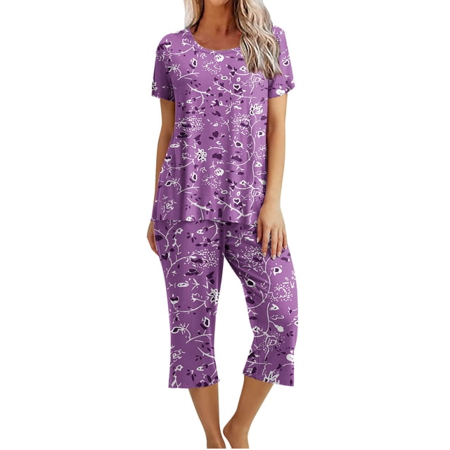 Womens Pajamas Set Shorts featuring a purple printed round neck short sleeve top and matching capri-length pants. This loungewear set, made of breathable cotton, is designed for comfort and casual wear during summer and spring. The top includes a relaxed fit with a floral-inspired print, and the pants feature an elastic waistband and pockets for convenience. Ideal for women's sleepwear, daily use, staycations, or casual gatherings.