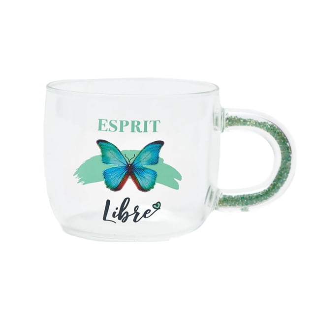 Chantal Lacroix - “Esprit Libre” glass cup with a 350ml capacity, featuring a turquoise butterfly design and the French phrase 'Esprit Libre' printed on the front. The handle is adorned with turquoise sparkles, adding a unique charm to the clear glass construction. Ideal for premium drinkware collections.