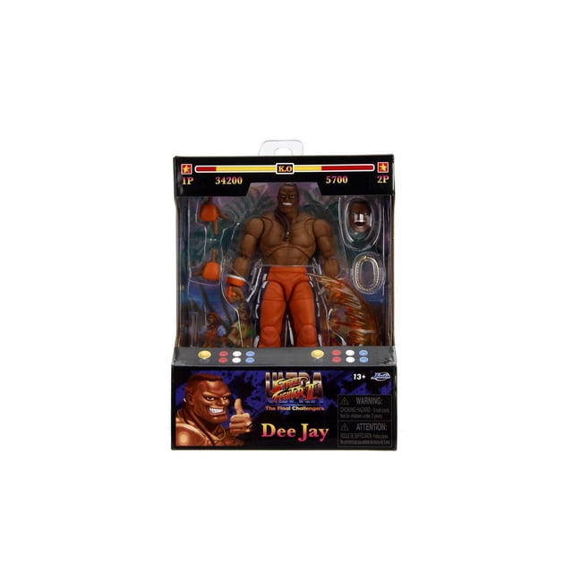 Jada Toys STREET FIGHTER II ACTION FIGURE - Dee Jay, a 6-inch articulated figure with muscular build wearing orange pants and wristbands, displayed in arcade-style packaging featuring game score and health bars, includes interchangeable hands and accessories for dynamic posing.