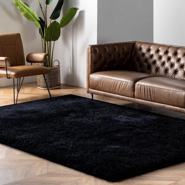 LaDole Rugs 3x10 ft Fluffy Shaggy Area Runner Rug in black, displayed in a modern living room setting with a brown leather sofa, a tan accent chair, and a potted plant. This machine washable long carpet features a high-pile texture, offering a plush and cozy feel underfoot. Ideal for hallways, kitchens, entryways, and other indoor spaces, it is designed for durability and easy maintenance, making it suitable for high-traffic areas.