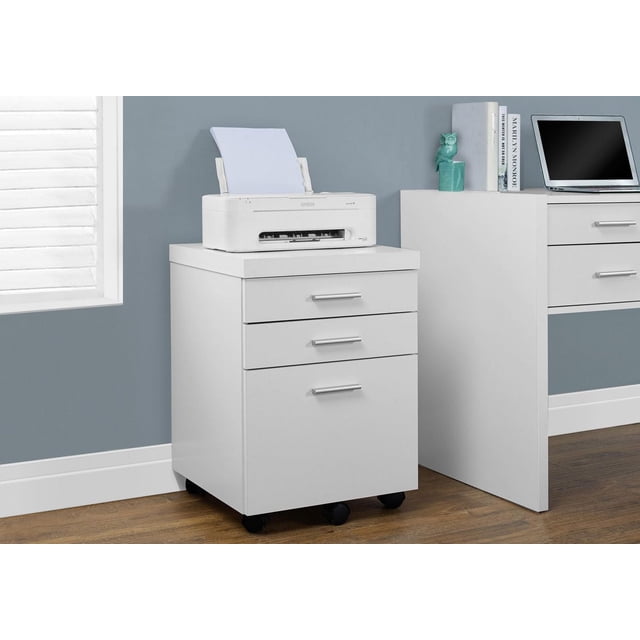 Monarch Specialties File Cabinet, Rolling Mobile, Storage Drawers, Printer Stand, Office, Work, Laminate, White, Contemporary, Modern. Front view of a white laminate 3-drawer filing cabinet with silver plastic handles on five castors (two locking), supporting a white Epson printer. Positioned on a wood floor against a blue wall near a window with white blinds, suitable for office storage and printer organization.