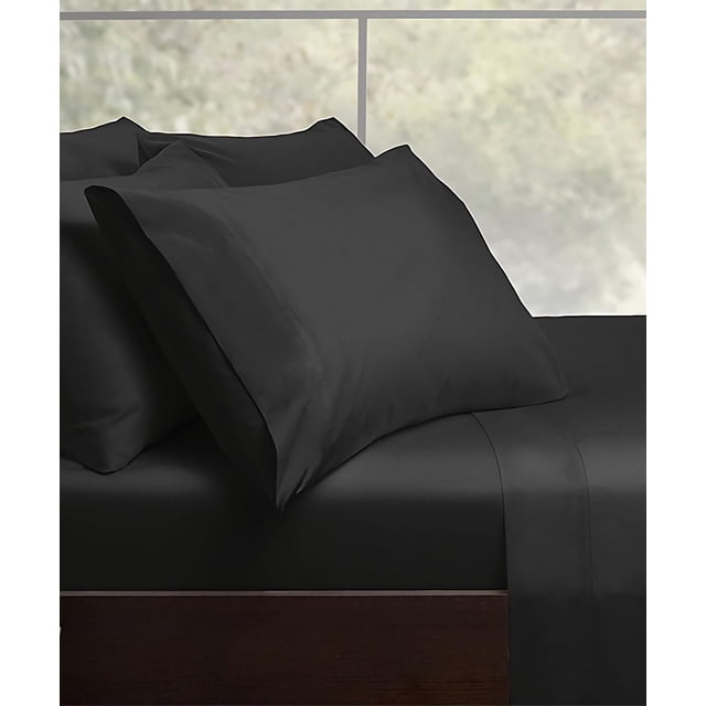 Malibu Home Satin Charmeuse Bed Sheet Sets in black, made of smooth, wrinkle-free polyester sateen with 15-inch deep pockets on the fitted sheet, shown on a dark wood bed frame by a window, often used to add a silky touch and durable comfort to bedroom bedding.