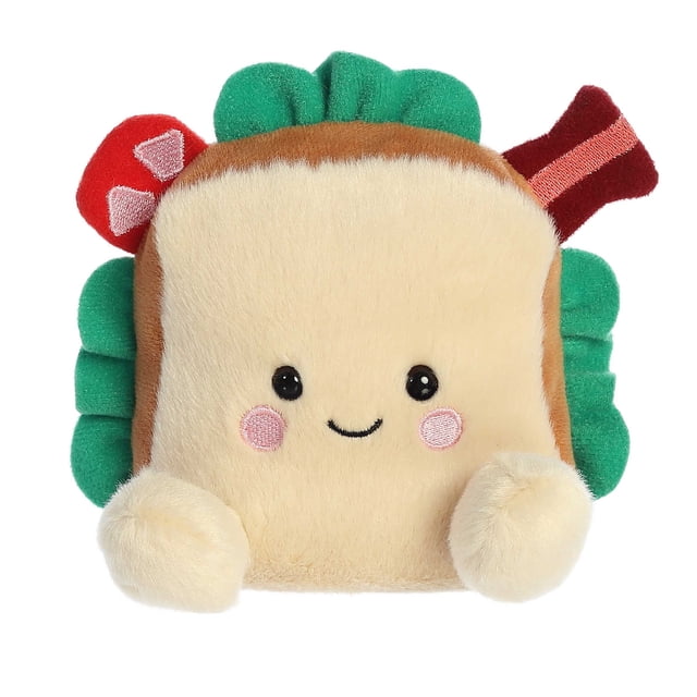 Aurora Palm Pals - Tomas BLT 5-inch plush toy designed as a sandwich with a beige, bread-like body, green lettuce tufts, and red tomato slices. Features round black eyes, a simple smile, and soft, fluffy material with bean pellets for stability. Suitable for all ages and part of the #palmpalsparty collection.