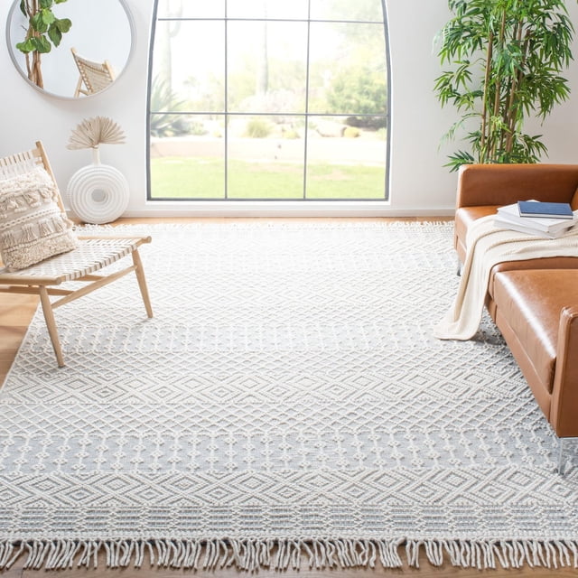 SAFAVIEH Natura Tapis en Laine à Franges du Sud-Ouest pour Salon Lumineux avec Grande Fenêtre. le Tapis Tissé à la Main Présente un Motif de Mosaïque du Sud-Ouest avec des Boucles Surdimensionnées, des Tissage Plats et des Bords à Franges dans des Tons Neutres. Il s'Agence avec une Chaise en Bois Tressée, un sofa en Cuir Brun avec un Jeté Crème et des Livres, et une Grande Plante Verte, Convient à la Déco Décontractée Ou de Maison de Plage.