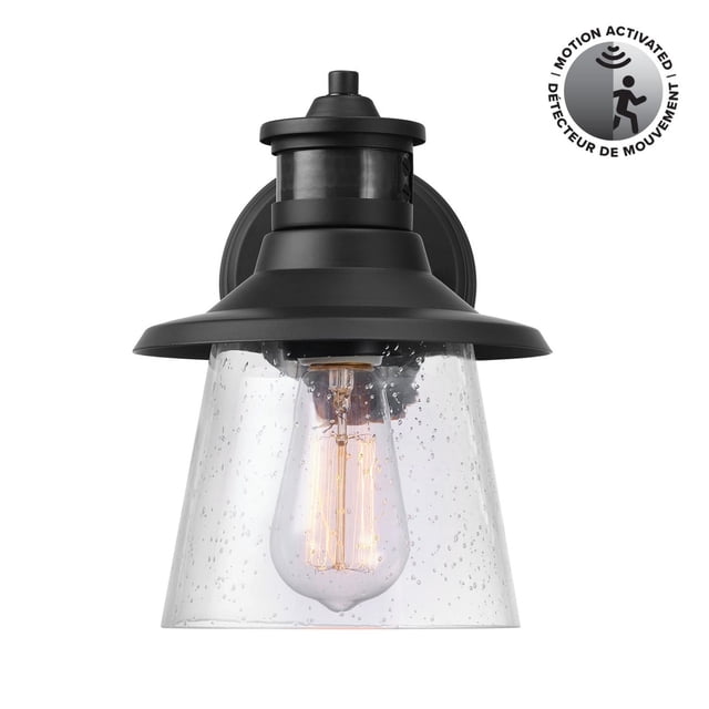 1-Light Matte Black Motion Sensor Outdoor Wall Sconce with Clear Seeded Glass Shade, featuring a matte black metal frame and clear seeded glass shade enclosing a filament bulb, motion-activated with 150-degree detection for outdoor security and farmhouse-style lighting.