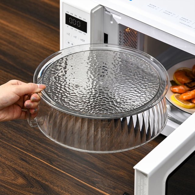 EGNMCR Couvercle Anti-Éclaboussures pour Micro-Ondes, Couvercle de Protection en Plastique Transparent pour Micro-Ondes avec Évents de Vapeur Ajustables, Présenté comme Placé sur une Assiette d'Aliments à l'Intérieur d'Un Micro-Ondes. le Couvercle a une surface Supérieure Texturée et un Côté Nervuré, Mesure 11,6 Pouces de Diamètre et 3,74 Pouces de Hauteur. Conçu pour Empêcher les Éclaboussures d'Aliments et Garder le Micro-Ondes Propre, Il Présente une Poignée Pratique pour un Levage Facile.