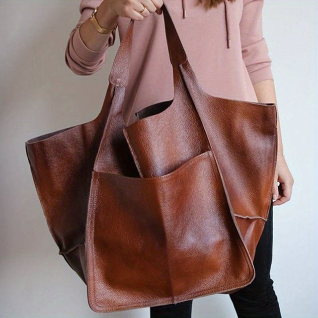Rretro Grand Sac Fourre-Tout, un Sac Fourre-Tout à Bandoulière à Fermeture Éclair de Grande Capacité de Couleur Unie en Matériau Synthétique. le Sac Présente une Fermeture Magnétique, des Bretelles d'Épaule Fixes et un design Multifonctionnel. Montré dans une Couleur Brun Riche, Il a un Intérieur Spacieux et Sans Motif, le Rendant Adapté à Divers Usages.