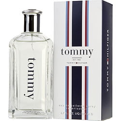 TOMMY HILFIGER by Tommy Hilfiger, EDT SPRAY 6.7 OZ in new packaging. The clear glass bottle features the iconic Tommy branding, paired with a striped box design in red, white, and blue. This citrus aromatic perfume for women includes notes of bergamot, red apple, cranberry, rose, amber, cactus, and cotton flower.
