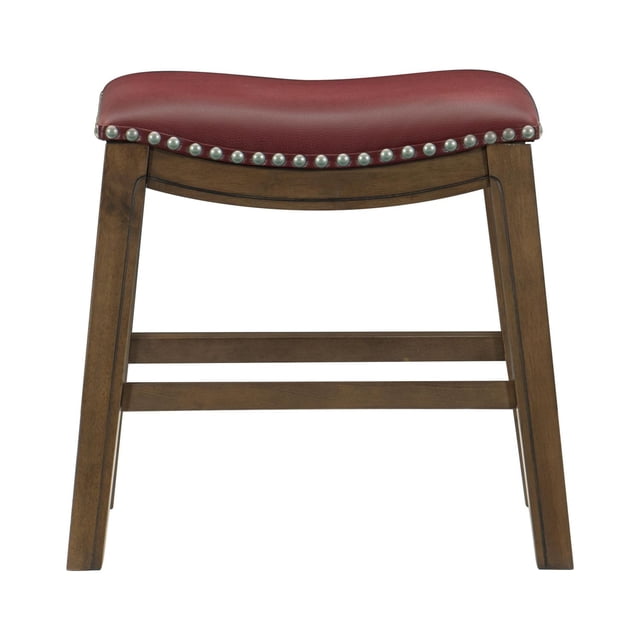 Topline Home Furnishings Stool, Faux Leather with a red curved saddle seat outlined by silver-toned nailhead trim, foam-padded for comfort, supported by a brown wood frame with built-in footrest rails, 18 inches high, suitable for kitchen or dining seating and often used as an accent stool.