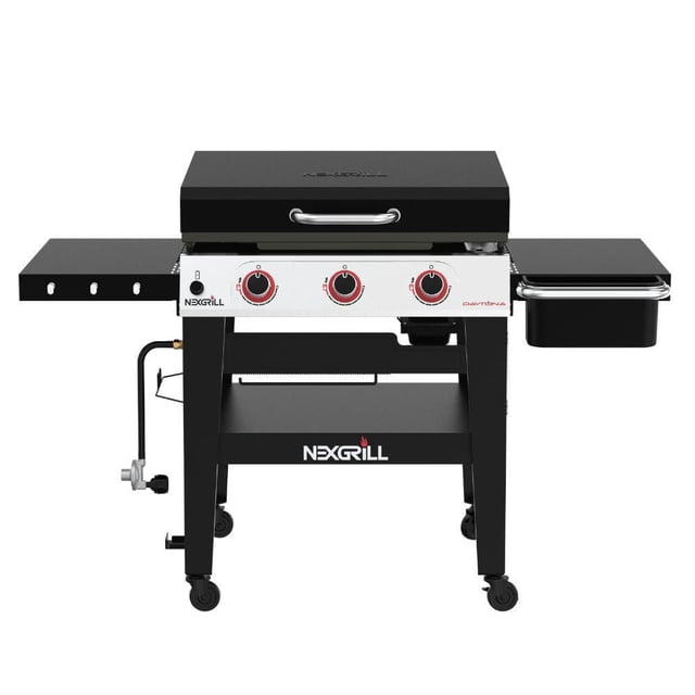 Daytona 3-Burner 30" Propane Gas Griddle with Lid with a black flat top cooking surface and heavy-duty lid, three red-accented stainless steel control knobs on a white panel, side shelves with utensil caddy, mounted on four caster wheels for mobility, propane connection on the left, and Nexgrill branding on the front lower shelf. This outdoor griddle provides 630 sq. in. cooking space and a grease management system for easy cleaning.
