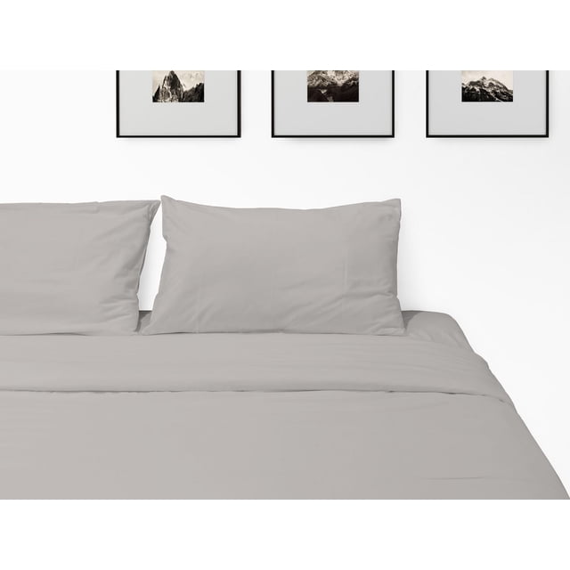 Johnson Home 500 Thread Count Certified Organic Cotton Sheet Sets in light grey, displaying a neatly made bed with two matching pillowcases and a flat sheet, set against a white wall with three black-framed mountain landscape photos above.